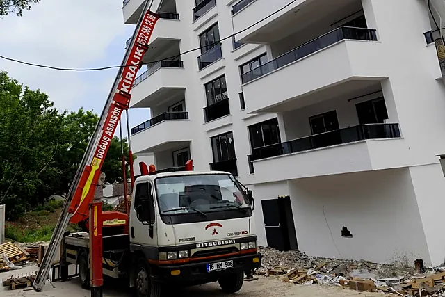 Sokakta kurulmuş Doğuş asansörlü aracı ve kırmızı asansör kolu