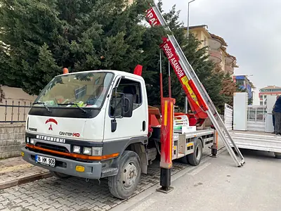 Sokakta kurulmuş Doğuş asansörlü aracı ve kırmızı asansör kolu