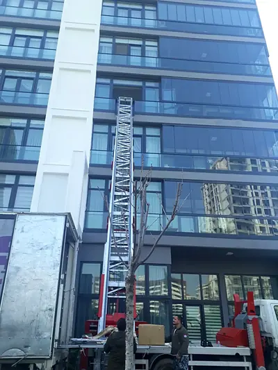 Cam cepheli binanın önünde kamyona yanaşmış eşya asansörü